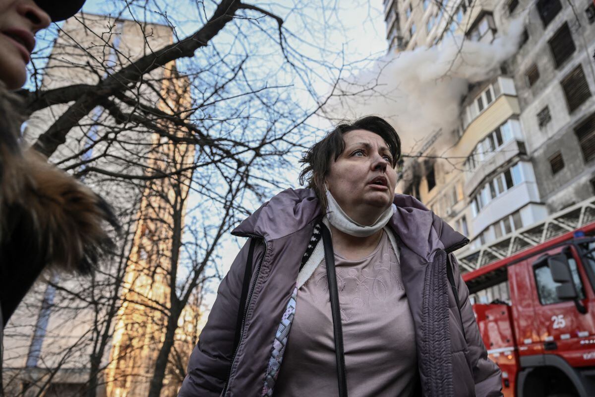 A woman reacts after being evacuated from a burning apartment building in kyiv on March 15, 2022. (ARIS MESSINIS / AFP)