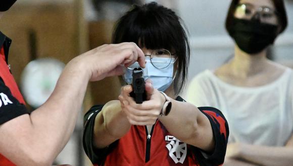 Esta foto tomada el 18 de junio de 2022 muestra a un civil taiwanés apuntando con una réplica de una pistola como parte de un taller de armas de fuego en el distrito de Linko, en la ciudad de Nuevo Taipéi. (Sam Yeh / AFP)