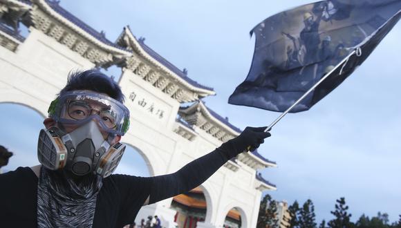 Imagen referencial en la que una persona iza una bandera en la Plaza de la Democracia de Taipéi. AP