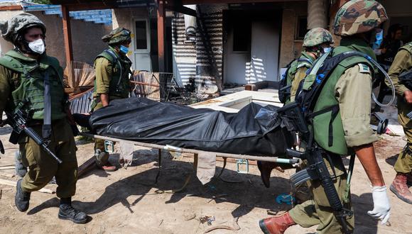 Soldados israelíes retiran el cuerpo de un compatriota muerto durante un ataque de militantes de Hamás en Kfar Aza, al sur de Israel, en la frontera con la Franja de Gaza