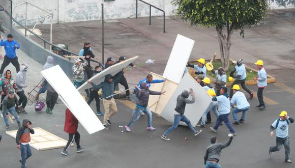 Con palos y tablones, hinchas de Alianza Lima y miembros de una iglesia cristiana se enfrentaron en la explanada de Matute. 
 (Foto: Lino Chipana / El Comercio)