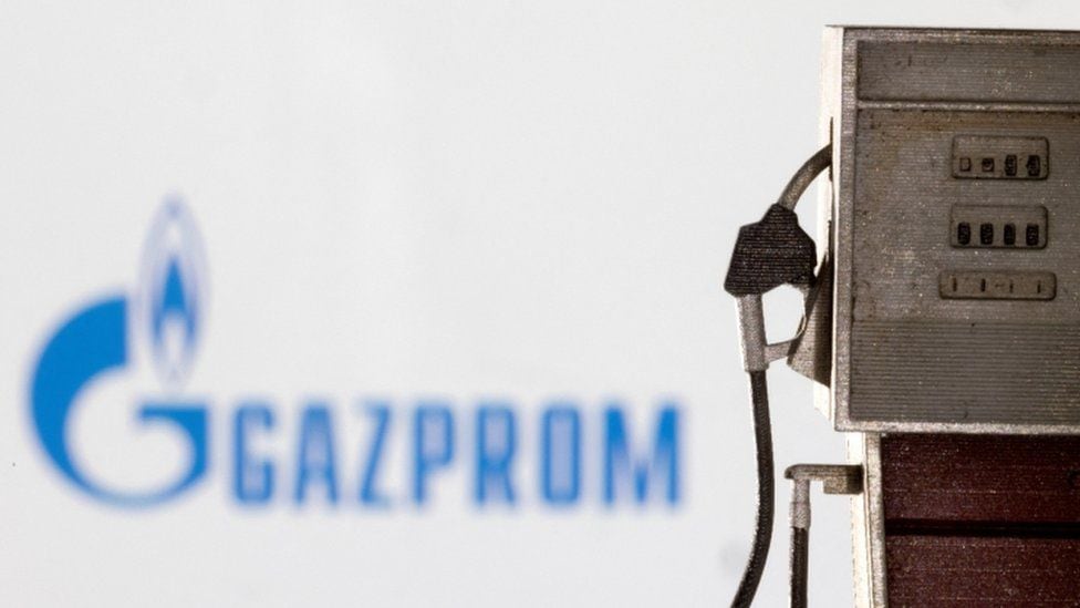 A gasoline pump in front of a sign for the Russian state-owned company Gazprom.  (Reuters).