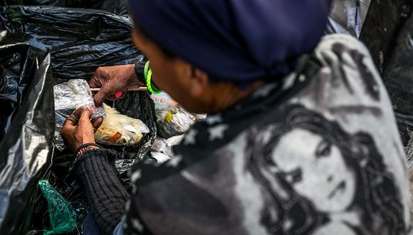 ACOMPA—A CR”NICA: VENEZUELA CRISIS. CAR07. CARACAS (VENEZUELA), 25/09/2017.- FotografÌa fechada el 20 de septiembre de 2017 que muestra a una mujer mientras hurga en una basura en busca de comida en una calle de Caracas (Venezuela). En las calles de Caracas deambulan cada vez m·s niÒos y de menos edad. Se trata, seg˙n analistas y activistas de derechos humanos, de una nueva oleada de pequeÒos que pr·cticamente han abandonado sus hogares, aunque esta vez la razÛn es una sola: "La falta de comida en sus casas". EFE/Miguel GutiÈrrez