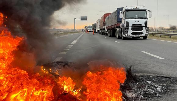 Los camiones que bloquean una carretera se muestran cerca de una barricada en llamas mientras los camioneros argentinos protestan contra la escasez y el aumento de los precios del combustible diesel, justo cuando la crucial cosecha de granos del país requiere transporte en medio de la creciente inflación, en San Nicolás, Argentina.