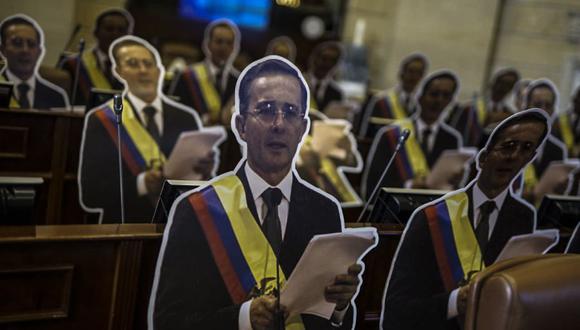 Figuras de tamaño natural del expresidente colombiano Álvaro Uribe colocadas en asientos en la Sala Elíptica del Congreso Nacional en Bogotá, el 14 de agosto de 2020. (AFP).