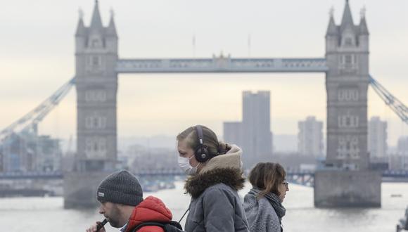 Un grupo de personas que usa máscara facial protectora contra el coronavirus camina sobre el Puente de Londres, en el Reino Unido. (Simon Dawson / Bloomberg).