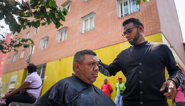Bajo los puentes, en los cruces de calles o en plena acera, los peluqueros de Caracas inundan la vía pública con improvisados puestos de trabajo. (EFE)
