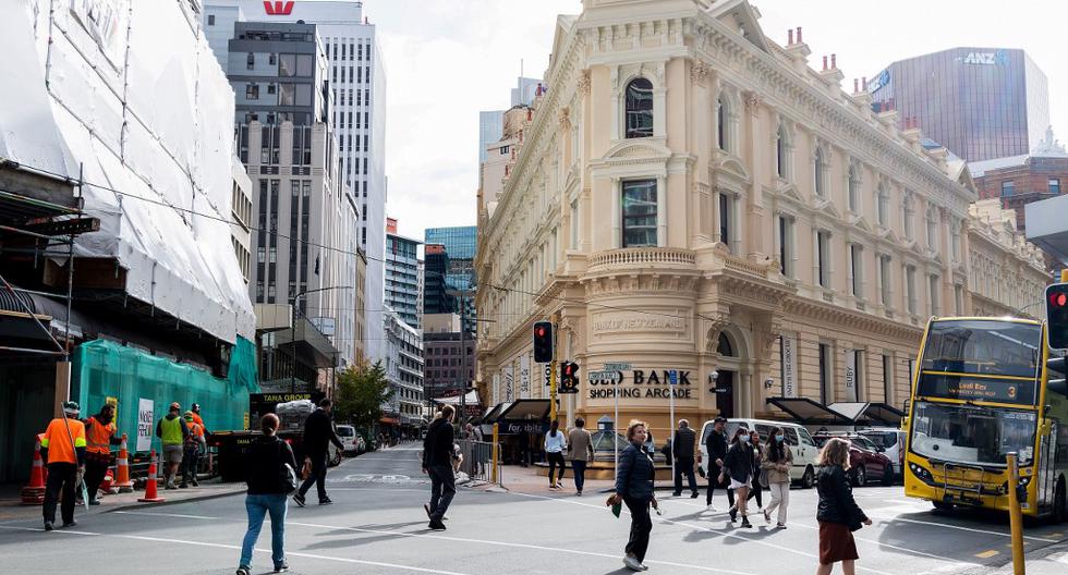 La gente camina en una calle en Wellington el pasado 14 de mayo,fecha en que se reabrieron centros comerciales, restaurantes, cines y parques infantiles, luego del anuncio de la eliminación de algunas restricciones por la pandemia del coronavirus. (Marty MELVILLE / AFP)