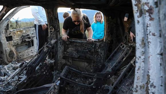 Integrantes de la familia LeBarón junto a uno de los vehículos atacados por los asesinos. (AFP).