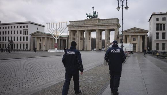 Alemania inició un cierre más duro en un esfuerzo por reducir el alto número de casos de coronavirus COVID-19. En la imagen, oficiales de policía patrullan en un desierto de la Pariser Platz frente a la Puerta de Brandenburgo en Berlín. (Foto: AP / Markus Schreiber)