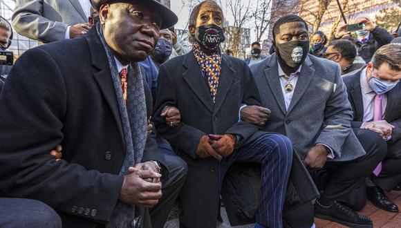 El abogado de la familia de George Floyd, Ben Crump (izquierda) y el reverendo Al Sharpton, fundador y presidente de National Action Network, (C) y el hermano de George Floyd se arrodillan en el día de la apertura del juicio por su asesinato. (Foto de Kerem Yucel / AFP).