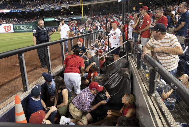 Fans take cover after apparent shots were heard during the game between the Washington Nationals and the San Diego Padres in the National Park.