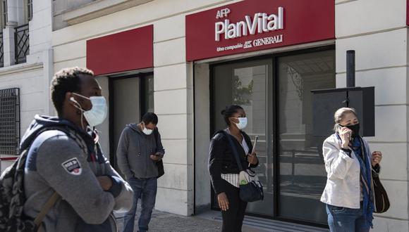 Personas hacen cola frente a la oficina de una Administradora de Fondos de Pensiones (AFP) para realizar trámites para retirar sus fondos en Santiago de Chile, el 26 de abril de 2021. (Foto de MARTIN BERNETTI / AFP).