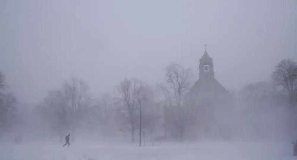 Un peatón solitario con raquetas de nieve cruza Colonial Circle cerca de la Iglesia Episcopal St. John's Grace en Buffalo, Nueva York, el sábado 24 de diciembre de 2022. (Derek Gee/The Buffalo News vía AP).