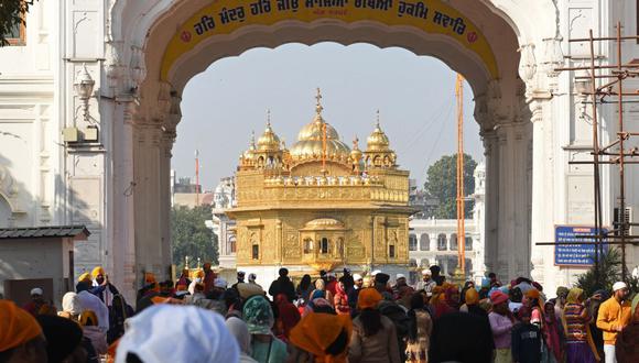 Los devotos sij llegan al Templo de Oro en Amritsar, India, el 19 de diciembre de 2021, un día después de que un hombre fuera golpeado hasta la muerte por supuestamente intentar cometer un acto de sacrilegio en el santuario. (Narinder NANU / AFP).