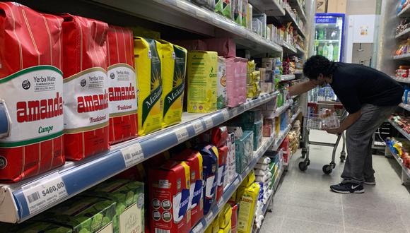 Un hombre organiza productos en un supermercado en Buenos Aires, el 16 de septiembre de 2022. - Argentina tiene actualmente una de las tasas de inflación más altas del mundo con 56,4 por ciento durante los primeros ocho meses del año. (Foto por Luis ROBAYO / AFP)