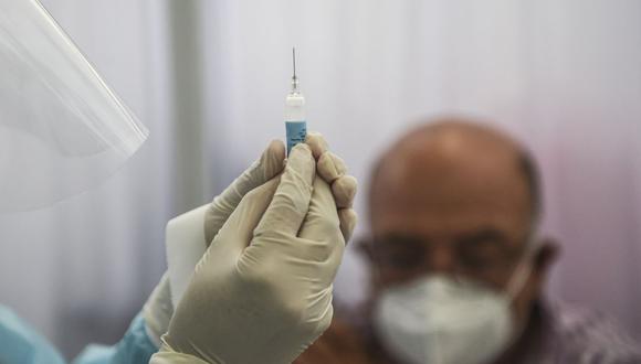 Un trabajador de salud prepara una jeringa para inocular a un voluntario con una vacuna COVID-19 producida por la China Sinopharm durante su ensayo en el Centro de Estudios Clínicos de la Universidad Cayetano Heredia en Lima el 09 de diciembre de 2020 (Foto: Ernesto Benavides / AFP)