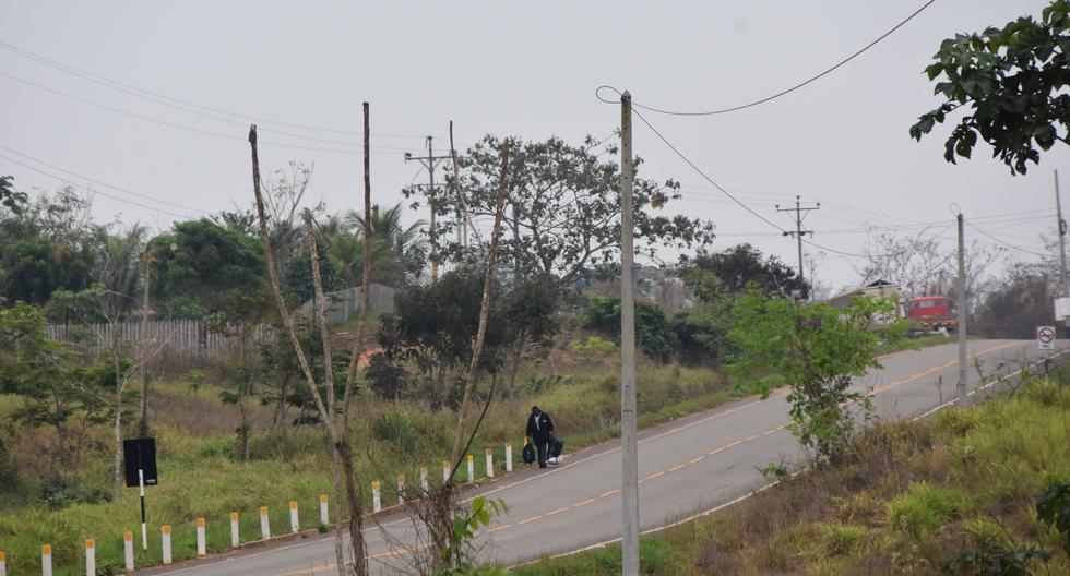 Un ciudadano haitiano camina por la vía interoceánica luego de haber sido pasado por "coyotes", en la frontera de Iñapari. (Manuel Calloquispe / El Comercio)