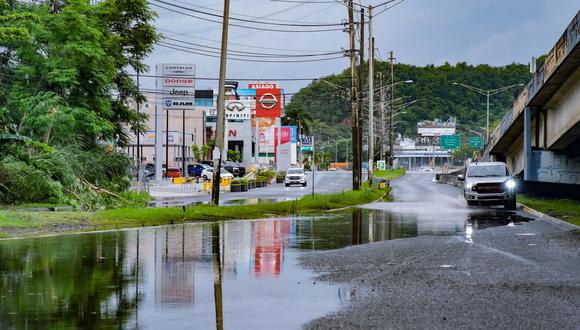Autos circulan por una avenida Kennedy inundada en San Juan, Puerto Rico, el 19 de septiembre de 2022, tras el paso del huracán Fiona. (Foto por AFP)