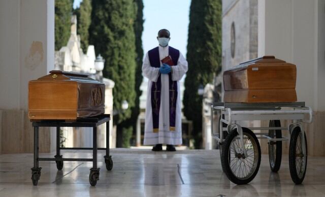 Los ataúdes de dos víctimas de coronavirus se ven durante una ceremonia de entierro en la ciudad sureña de Cisternino, Italia. (REUTERS / Alessandro Garofalo).