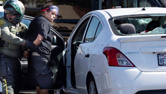 Una mujer no identificada es detenida después de que testigos dijeron que condujo su automóvil contra una multitud de manifestantes en Yorba Linda, California. (Foto: AP/Mindy Schauer/The Orange County Register).
