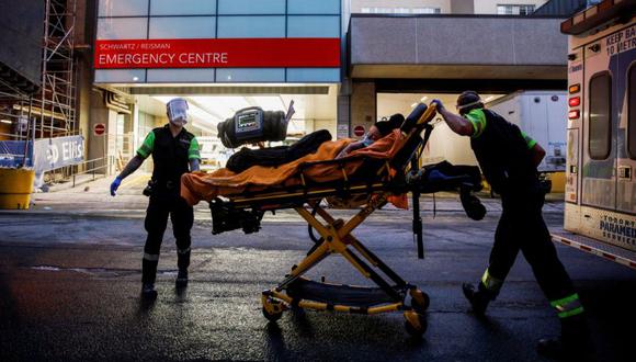 Los miembros de la tripulación de la ambulancia entregan a un paciente en el Hospital Mount Sinai cuando las autoridades advirtieron sobre un "tsunami" de nuevos casos de enfermedad por coronavirus (COVID-19) en los próximos días y semanas debido a la variante Omicron en Toronto, Ontario, Canadá. (Foto: REUTERS/Cole Burston).