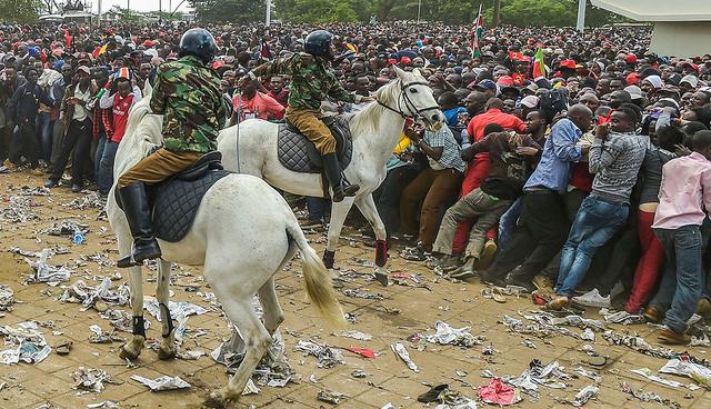 People back off as Kenyan Mounted Police intervenes outside Kasarani stadium in Nairobi during a stampede as supporters of Kenya's President try to get into the venue to attend his inauguration ceremony on November 28, 2017.
 President Uhuru Kenyatta vowed to be the leader of all Kenyans and work to unite the country after a bruising and drawn out election process that ended with his swearing-in. / AFP / SIMON MAINA