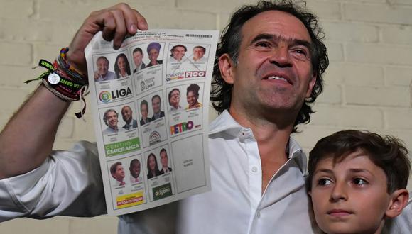 El candidato presidencial colombiano por la coalición Equipo Colombia, Federico Gutiérrez, muestra su papeleta junto a uno de sus hijos mientras vota en Medellín. (Joaquín SARMIENTO / AFP).