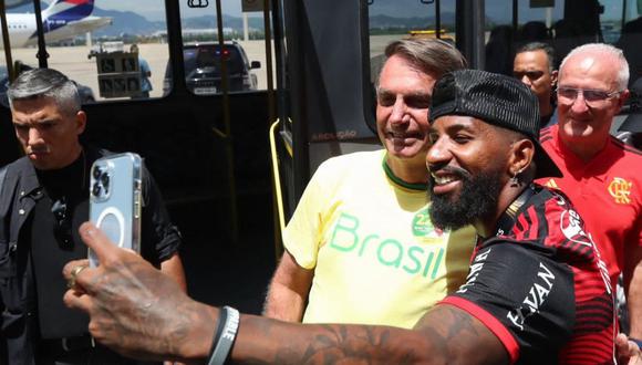 Imagen publicada por el Partido Liberal que muestra al presidente brasileño Jair Bolsonaro, posando para una foto con el defensor de Flamengo, Rodinei. (AFP).