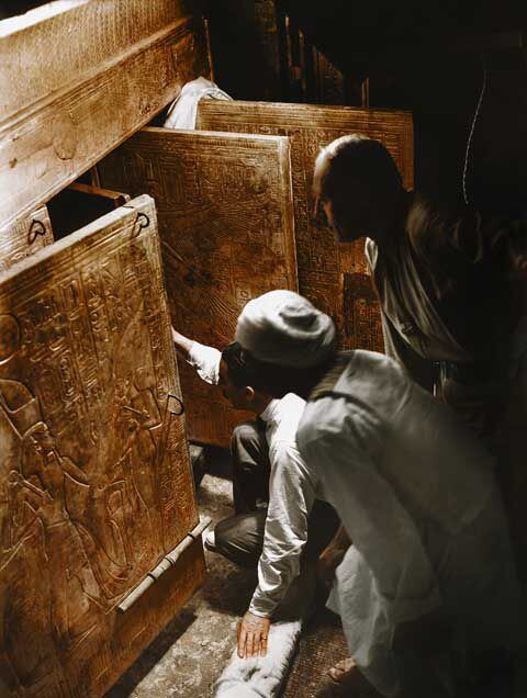 Carter, his assistant Arthur Callender, and an Egyptian worker look through one of the doors leading to the sarcophagus. 