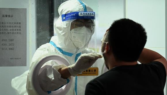 Un trabajador de la salud toma una muestra de hisopo de un hombre para detectar el coronavirus Covid-19 en Beijing el 21 de junio de 2022. (Foto de Noel Celis / AFP)