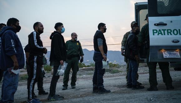 Los agentes de la Patrulla Fronteriza de EE.UU. suben a una camioneta de transporte a los migrantes atrapados cruzando la frontera entre Estados Unidos y México en Sunland Park, Nuevo México, el 22 de julio de 2021. (Foto: PAUL RATJE / AFP).