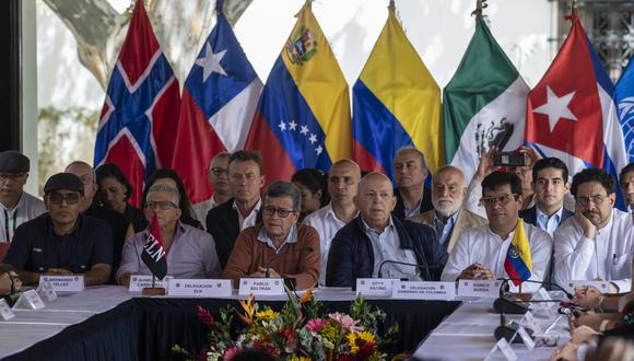 Los comandantes guerrilleros del Ejército de Liberación Nacional (ELN) de Colombia Bernardo Téllez (L), Aureliano Carbonell (2-L) y Pablo Beltrán (3-L), acompañados por el miembro de la delegación del gobierno colombiano Otty Patino (3-R), el Alto Comisionado para Paz, Danilo Rueda (2-R), y el Senador Iván Cepeda (R), escuchan la lectura de un documento luego de una reunión en el marco de las conversaciones de paz en el complejo "La Casona Cultural Aquiles Nazoa" en Caracas el 21 de enero de 2023. (Foto: Yuri CORTEZ / AFP)