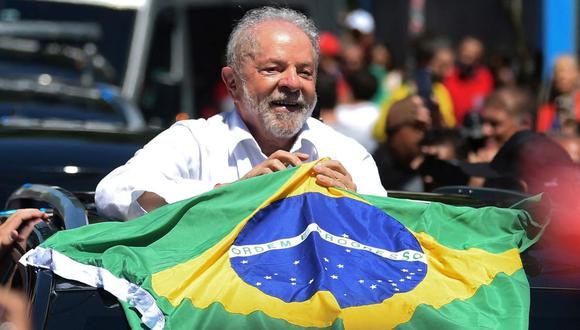 Luiz Inácio Lula da Silva sostiene una bandera brasileña al salir de un colegio electoral durante la segunda vuelta de las elecciones presidenciales en Brasil. (CARL DE SOUZA / AFP).