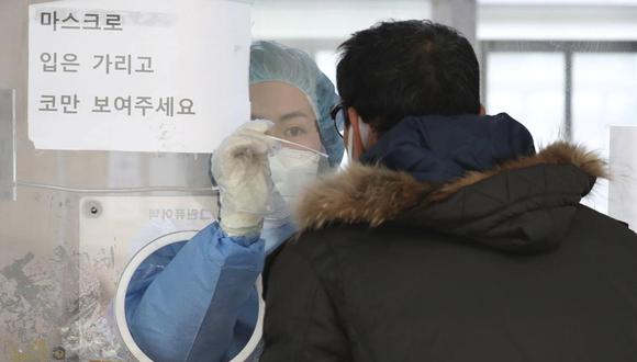 Personal sanitario toma una muestra de un hombre en una clínica de detección temporal de coronavirus en Seúl, Corea del Sur, el sábado 4 de diciembre de 2021. (Park Mi-so / Newsis vía AP).