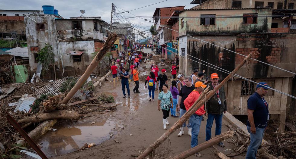 Personas observan los destrozos causados por el desbordamiento de la quebrada Los Patos, en Las Tejerías, estado Aragua, Venezuela. (EFE/ Rayner Peña R).