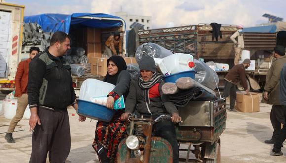 Los sirios que quedaron sin hogar después de que un devastador terremoto azotara su país reciben ayuda humanitaria mientras se instalan en un campamento improvisado instalado en una escuela en la ciudad de Atareb, en el campo occidental de la provincia de Alepo, controlado por los rebeldes, el 10 de febrero de 2023 (Foto: AAREF WATAD / AFP)