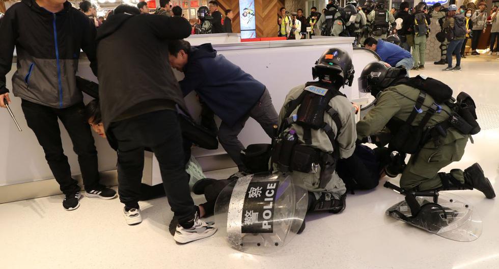 La policía antidisturbios detiene a unos manifestantes durante un mitin en el día de Navidad en el centro comercial Sha Tin en Hong Kong. (Reuters)