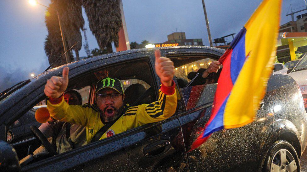 A man sticks his arms out of his car window to celebrate Petro's win.  (NATALIA PEDRAZA/EPA-EFE/REX/SHUTTERSTOCK).