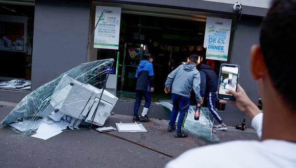 Gente irrumpe en un supermercado durante las protestas en Lille, en el norte de Francia, el 29 de junio de 2023, tras la muerte de un adolescente a manos de un policía en el suburbio parisino de Nanterre. (Foto de Kenzo TRIBOUILLARD / AFP)