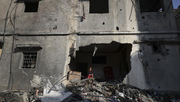Un niño palestino mira desde un edificio gravemente dañado la madrugada del 8 de agosto de 2022 en la ciudad de Gaza, luego de un alto el fuego entre Israel y los militantes palestinos. (Foto: Mahmud HAMS / AFP)
