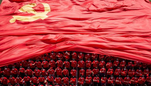 Estudiantes universitarios muestran una bandera del Partido Comunista de China para conmemorar su centenario durante una ceremonia de apertura del nuevo semestre en Wuhan, en la provincia central china de Hubei, el 10 de septiembre de 2021. (AFP).