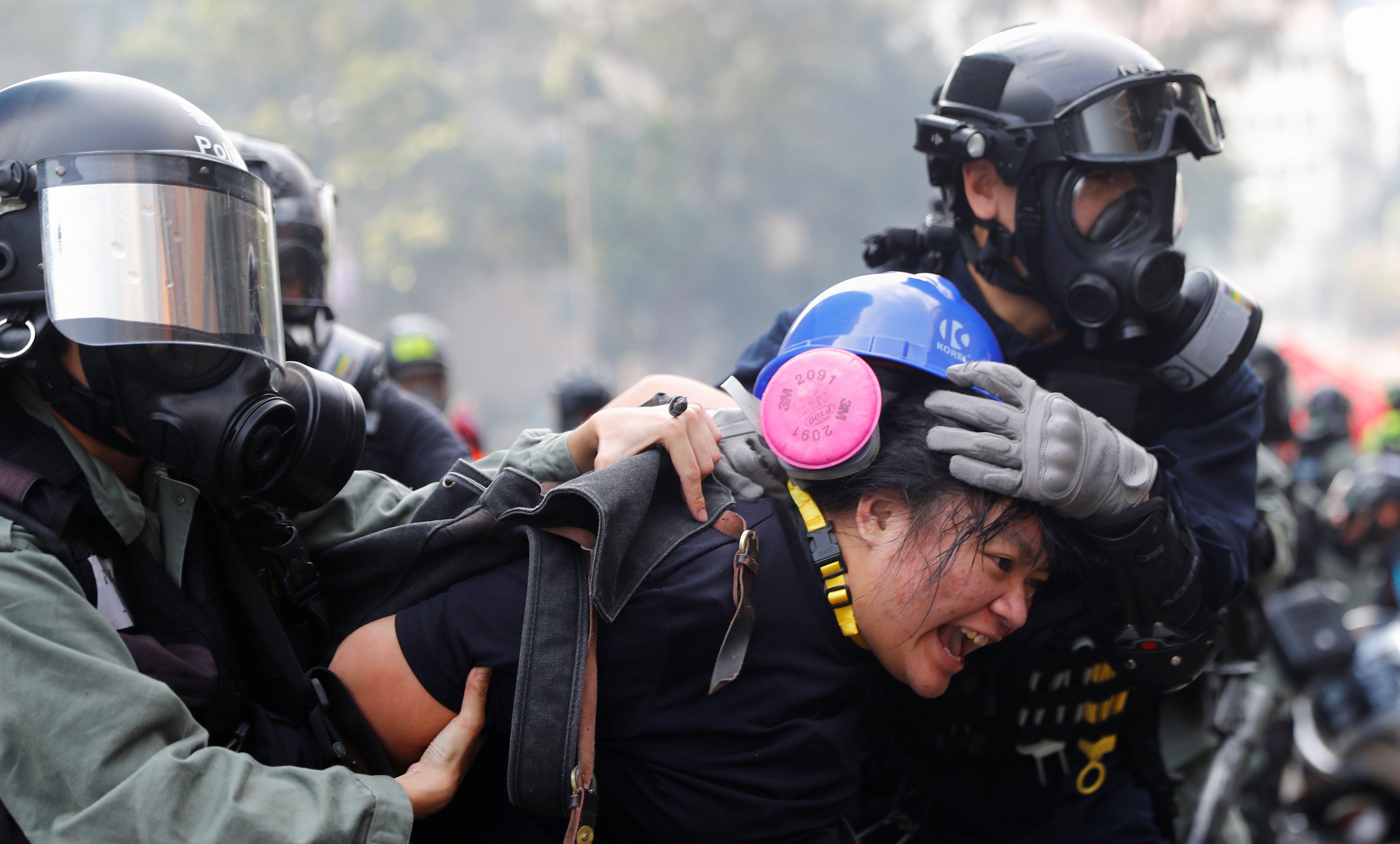 Una manifestantes es detenida por la policía de Hong Kong durante los enfrentamientos en la Universidad Politécnica. (REUTERS/Thomas Peter).