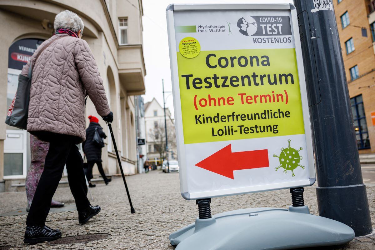 A woman walks past a coronavirus (covid-19) testing center in the eastern German city of Halle/Saale on January 25, 2022. (JENS SCHLUETER / AFP)