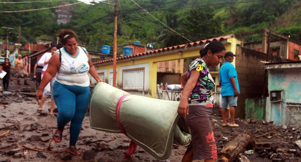 Residentes intentan recuperar pertenencias entre los escombros después de un deslizamiento debido a las fuertes lluvias en el sector de Valle Verde de Puerto La Cruz, estado de Anzoátegui, Venezuela. (Carlos LANDAETA / AFP).