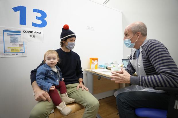 A father and daughter go to a vaccination center in London.  (AP).