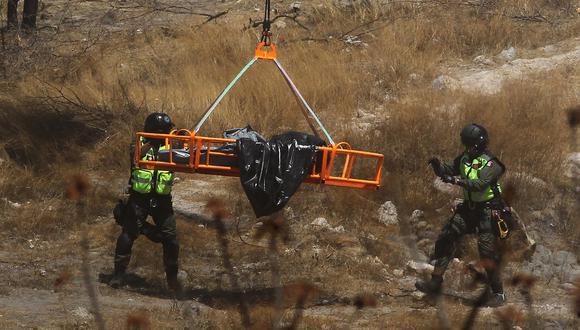 Peritos forenses trabajan con varias bolsas de restos humanos extraídos del fondo de un barranco por un helicóptero, abandonados en la comunidad Mirador Escondido en Zapopan, estado de Jalisco, México el 31 de mayo de 2023. (Foto de ULISES RUIZ / AFP)