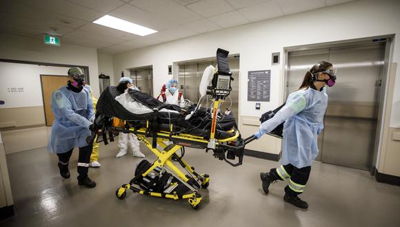 Paramédicos y trabajadores de la salud transfieren a un paciente de la Unidad de Cuidados Intensivos del Hospital Humber River. (Foto: Cole Burston / AFP)