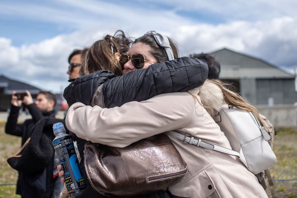Familiares de los desaparecidos se abrazan en una base militar de Punta Arenas. (Photo by Joel ESTAY / AFP).