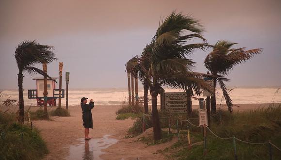 Una mujer toma una foto mientras los efectos del huracán Dorian comienzan a sentirse en Cocoa Beach, Florida. (Scott Olson / Getty Images / AFP ).